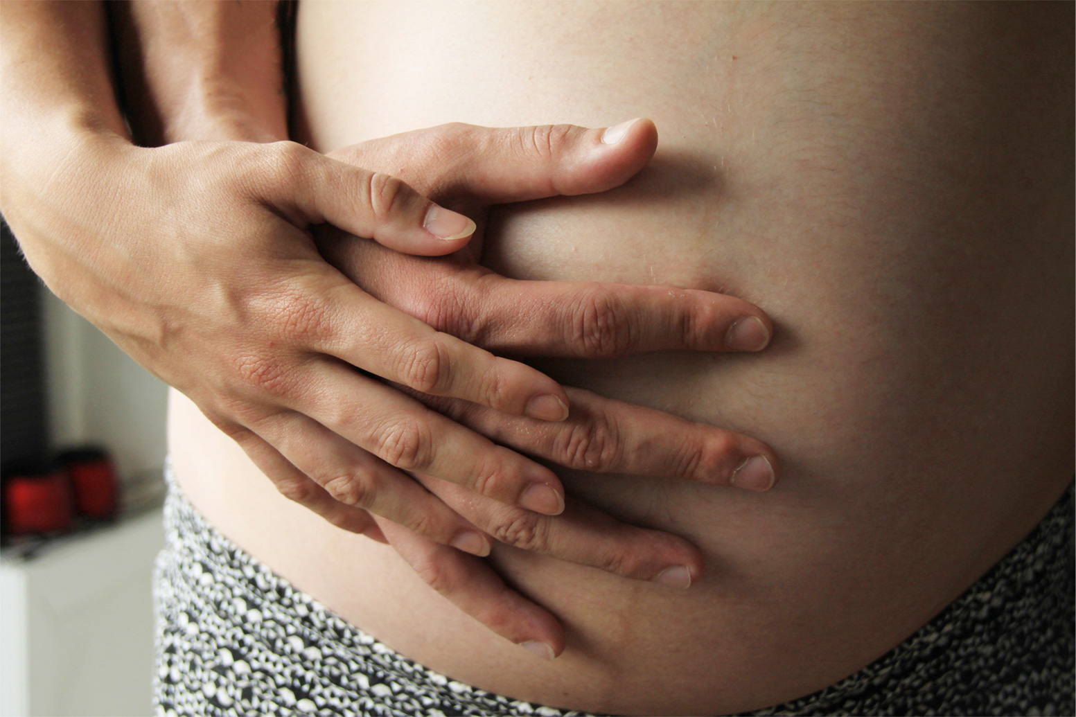 Zwangere buik met hand beide ouders.